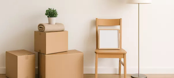 "Minimalistisk interiör med några flyttlådor och få ägodelar – symboliserar rensning och enkelhet inför en ny start vid flytt"
